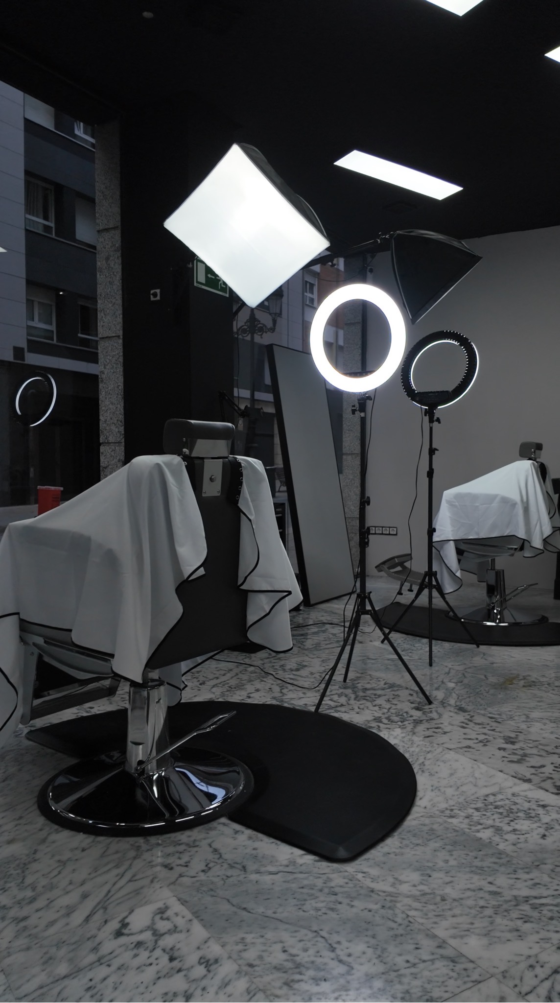 Zona principal de corte de Gentleman Barber Studios con sillones de barbería e iluminación circular